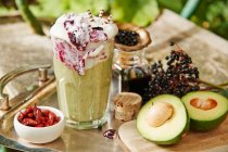 A smoothie with avocado, chili and elderberry frosting on a garden table — Stock Photo