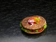 Close-up shot of delicious hamburger on a halved burger bun — Stock Photo