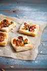 Savory pastries with goat cheese, half dried tomatoes, spinach and pine nuts — Stock Photo