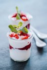Yoghurt dessert with strawberry jam, fresh strawberries and mint — Stock Photo
