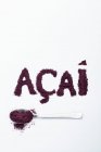 Acai berry polvere: su un cucchiaio e scritta su uno sfondo bianco — Foto stock