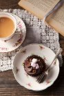 Um cupcake de chocolate coberto com mini marshmallows e salpicos de toffee — Fotografia de Stock