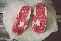 Rohe Ribeye-Steaks auf einem Stück Papier — Stockfoto