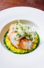 Sea bass fish fillet fricasee on a saffron risotto with wild fennel, basil, chilli — Stock Photo