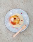 A baked apple with vanilla sacue and pomegranate seeds (seen from above) — Stock Photo