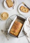 Banana bread in metal tin and slices on plates — Stock Photo