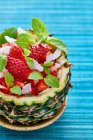 Фруктовый салат с клубникой подается в выдолбленном ананасе — стоковое фото
