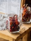 Dried red chili peppers in screw top jars — Stock Photo