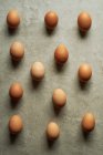 Brown eggs on gray surface, top view — Stock Photo