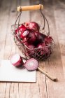 Rote Zwiebeln in einem Drahtkorb — Stockfoto
