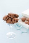 Schokoladenmacarons in einem langstieligen Glas — Stockfoto