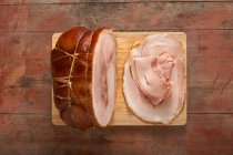 Roast ham, sliced, on a wooden board — Stock Photo