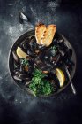Mussels in a white wine broth with lemon, parsley and toasted bread — Stock Photo