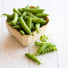 Mange tout in a wooden basket — Stock Photo