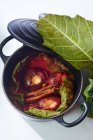 Жареные инжиры с корицей, завернутые в фиговые листья в мини-чайник — стоковое фото