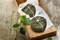 Two pecorino cheeses with stinging nettle rind on a wooden board — Stock Photo