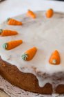 Морковный торт, украшенный глазурью и марципановой морковью — стоковое фото