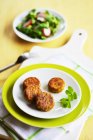 Small vegetable patties with a plate of salad — Stock Photo