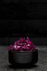 Red cabbage in a bowl on a wooden background — Stock Photo