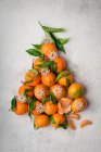 Clementines christmas tree with green leaves and decorative snowflakes — Stock Photo
