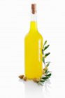 Оливковое масло в стеклянной бутылке на белом фоне — стоковое фото