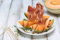Serrano ham on melon with balsamic sauce — Stock Photo