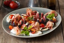 Tomato and mozzarella with figs and Serrano ham — Stock Photo