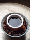 Grãos de café em uma tigela e uma xícara de café expresso em fundo bandeja de metal — Fotografia de Stock