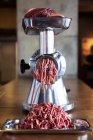 Beef in the mincer, mincing meat process — Stock Photo