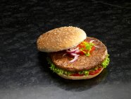 Гамбургер у кунжутній булочці з цибулею, помідорами, салатом та кетчупом — стокове фото