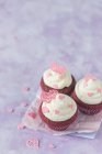 Червоні оксамитові кекси з вершковим сиром та рожевими цукровими сердечками — стокове фото