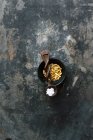 Pignons de pin rôtis dans un bol et cristaux de sel sur cuillère en bois — Photo de stock