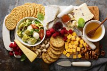 Assiette au fromage avec salade de tortellini, craquelins, fruits et noix — Photo de stock