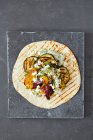 Ein Tortilla-Wrap mit gegrilltem Gemüse, Feta und Tzatziki — Stockfoto