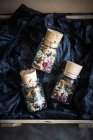 Pequenos frascos de chá de folhas soltas feitos de flores de ancião secas, hortelã, morangos e pêssego — Fotografia de Stock