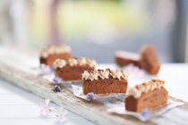 Rebanadas de pastel de chocolate moca con crema de almendras y chispas de chocolate en una tabla de madera (vegetariano) - foto de stock