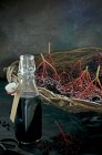 Garrafa de suco de sabugueiro, sabugueiros frescos em cesta de vime — Fotografia de Stock