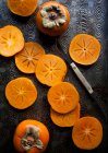 Persimmons, whole and sliced — Stock Photo