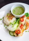 Coxas de frango tailandesas com fresco frio, pepino e salada de tomate, arroz basmati branco e caldo de cebolinha em um prato branco — Fotografia de Stock