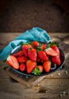 Fragole fresche in ciotola con panno blu — Foto stock