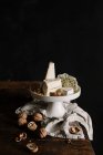 Різні сирні тарілки з волоськими горіхами на сільській дерев'яній поверхні — стокове фото