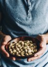 Cropped shot of person holding Bowl of pistachios — Stock Photo