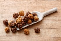 Energy balls with sunflower seeds, honey and cocoa on a wooden scoop — Stock Photo