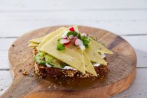 Uma fatia de pão coberto com queijo de ervas vegan e pepino — Fotografia de Stock