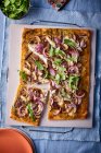 Pizza con confit di anatra, cipolle rosse e rucola — Foto stock