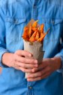 Man holds in his hands the fries of the sweet potato — Stock Photo
