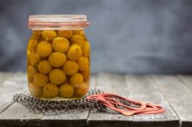 Preservate piccole prugne gialle in un barattolo di vetro — Foto stock