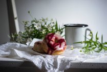Веганські пончики з двома видами глазурі на старому дерев'яному стільці з кавою та квітами — стокове фото