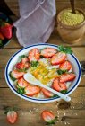 Rice porridge with fresh strawberries, herbs and spoon in bowl — Stock Photo