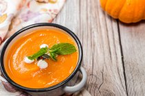 Homemade creamy pumpkin soup with mint in an enamel pot — Stock Photo
